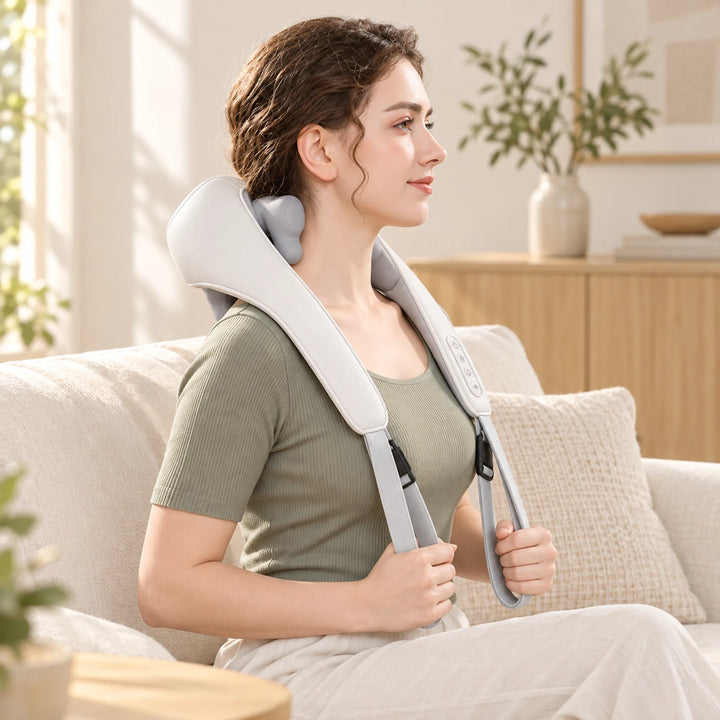 White cordless kneading massager arranged around shoulders during a seated break
