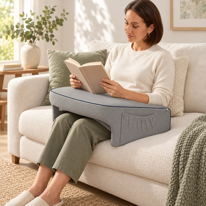 Gray cushioned lap desk supporting an open book while seated