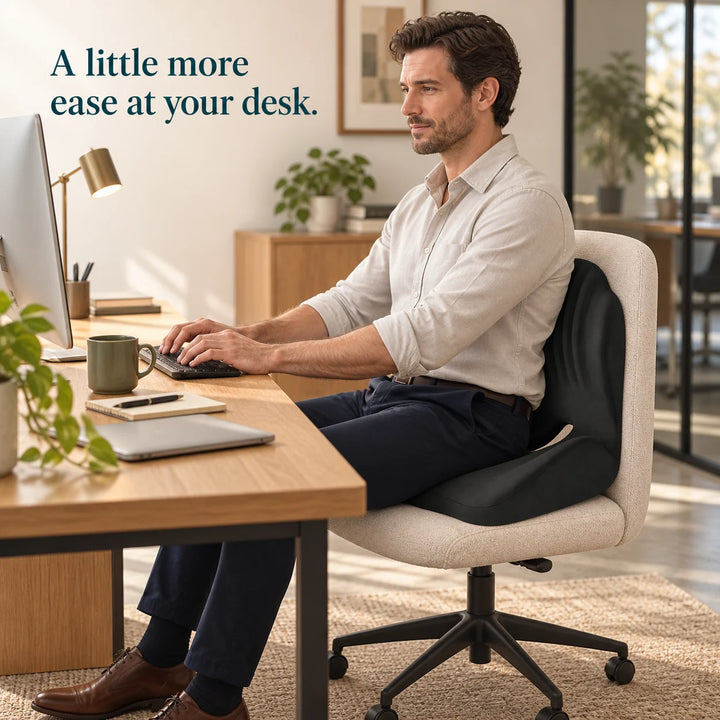 Black Easevora cushion shown in an everyday desk-work setting.